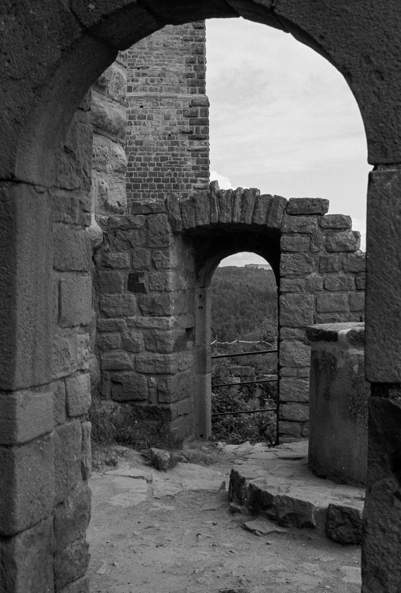 Deux ouvertures voûtées successives dans les murs d’une forteresse en ruine en noir et blanc