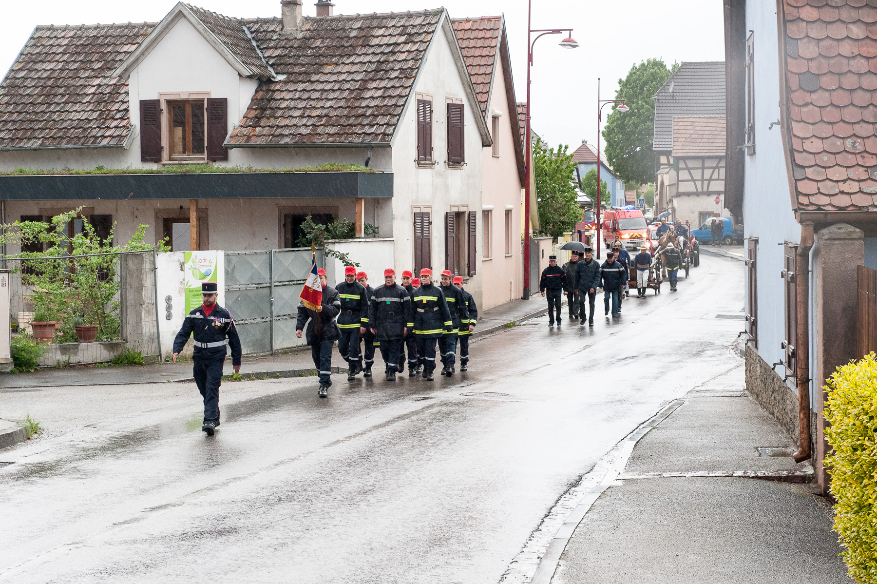 Sapeurs-pompiers marchant dans une rue du village de Sundhoffen