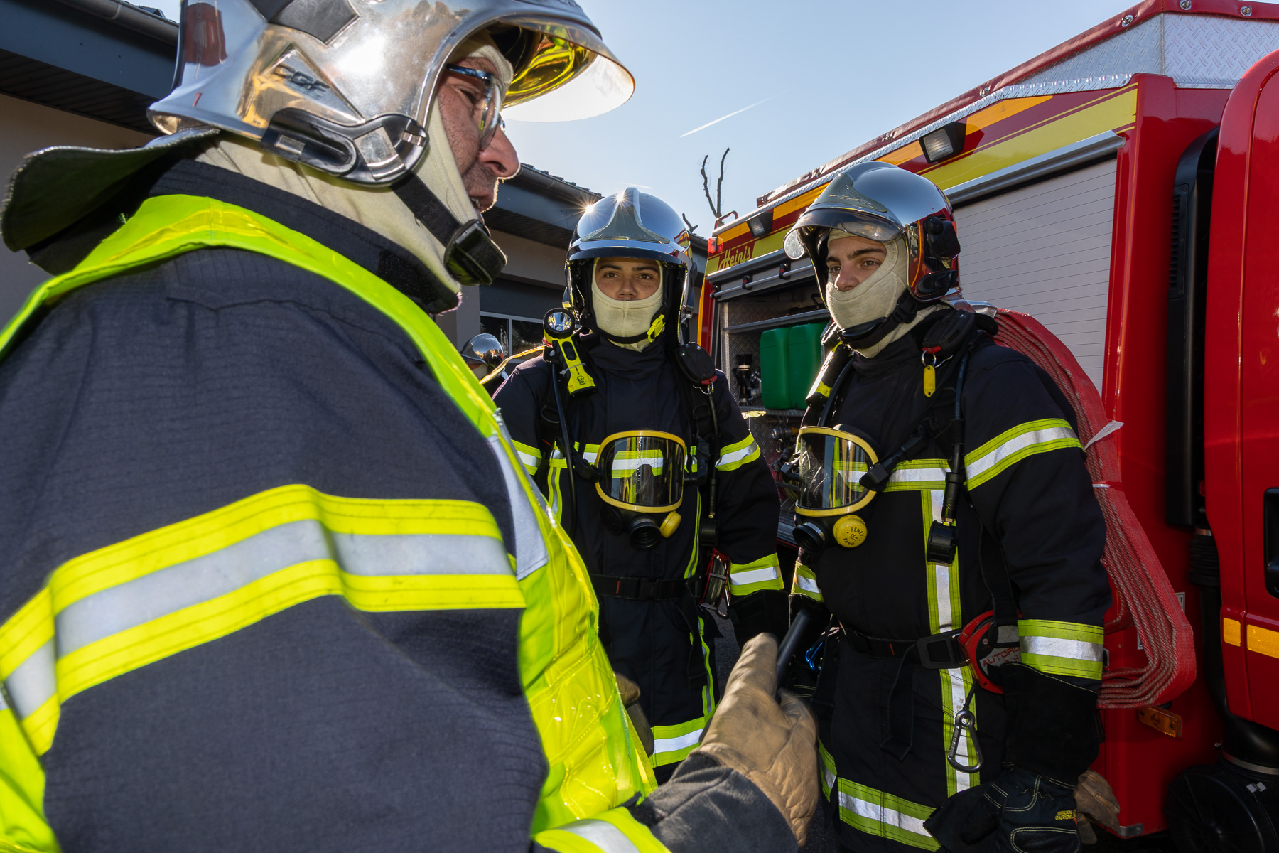 Équipe de sapeurs-pompiers échangeant autour du matériel d’intervention