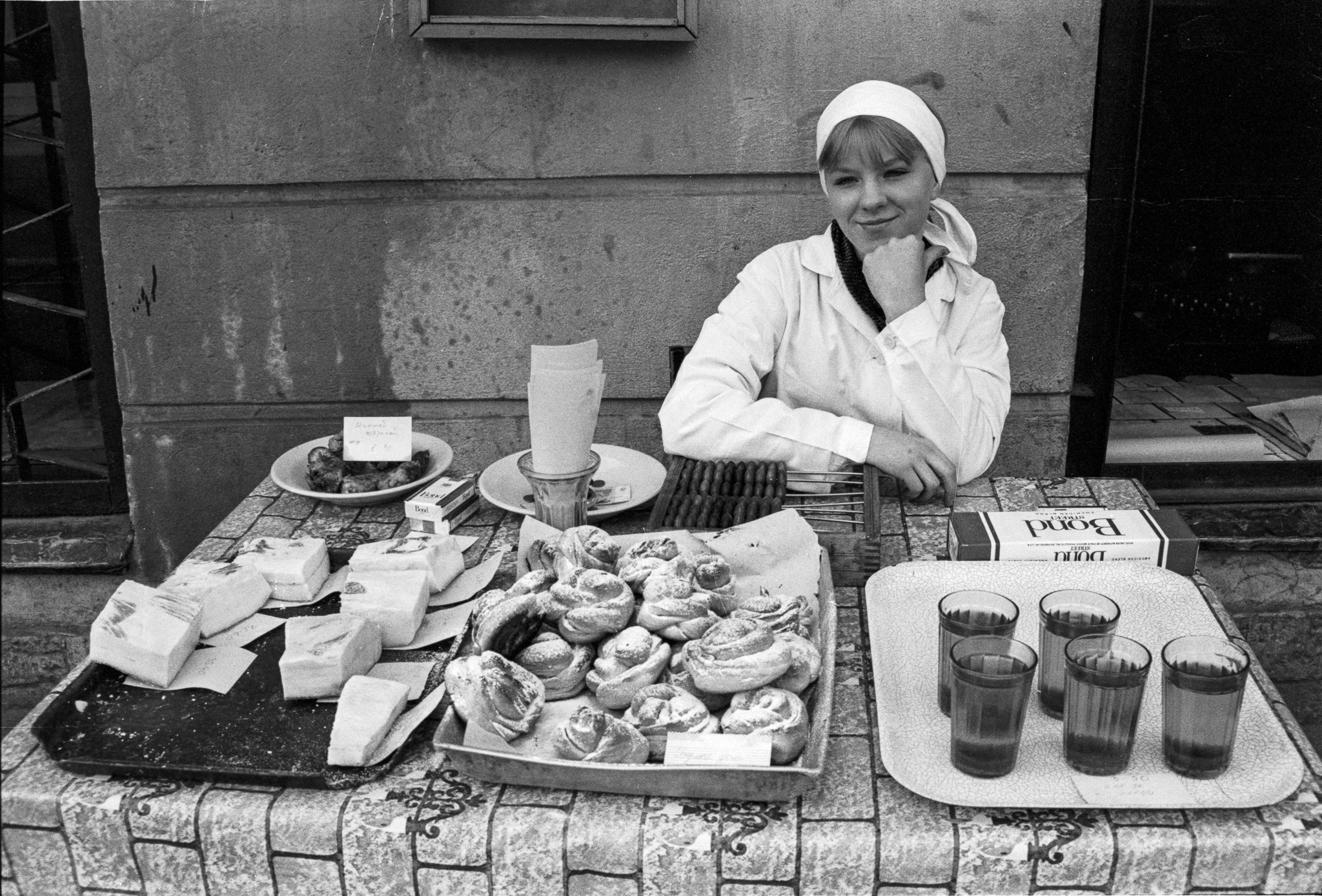 Femme derrière un étal de nourriture et de boissons dans une rue de Saint-Pétersbourg en 1992