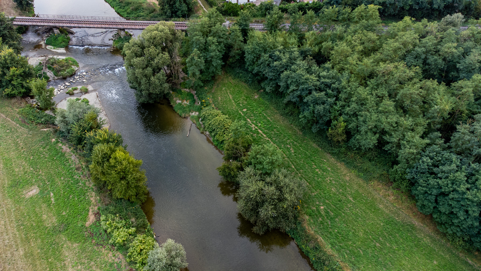 Vue aérienne de l’Ill serpentant entre des berges boisées et des espaces végétalisés