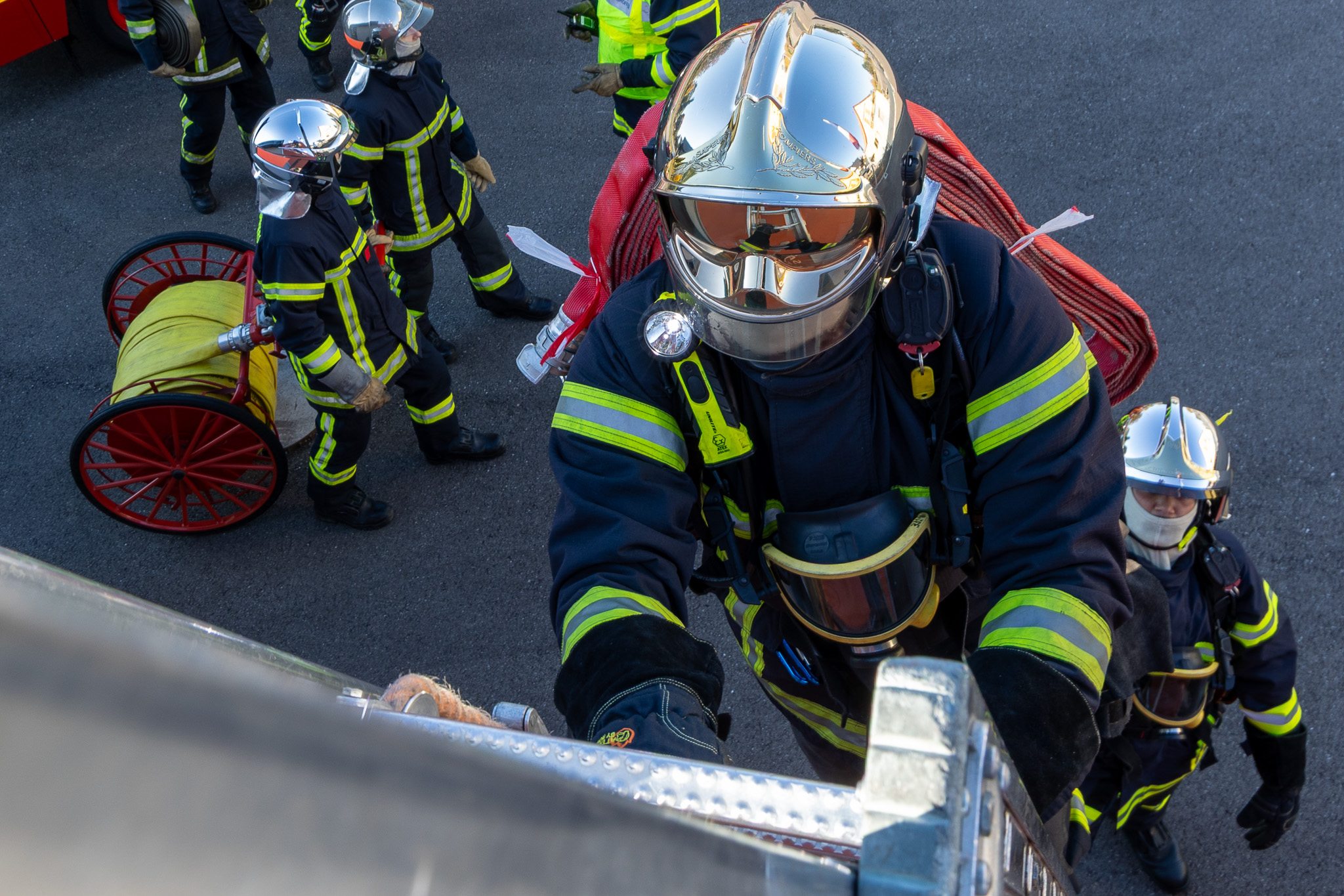 Sapeurs-pompiers engagés dans un exercice autour d’une échelle et d’un véhicule de secours