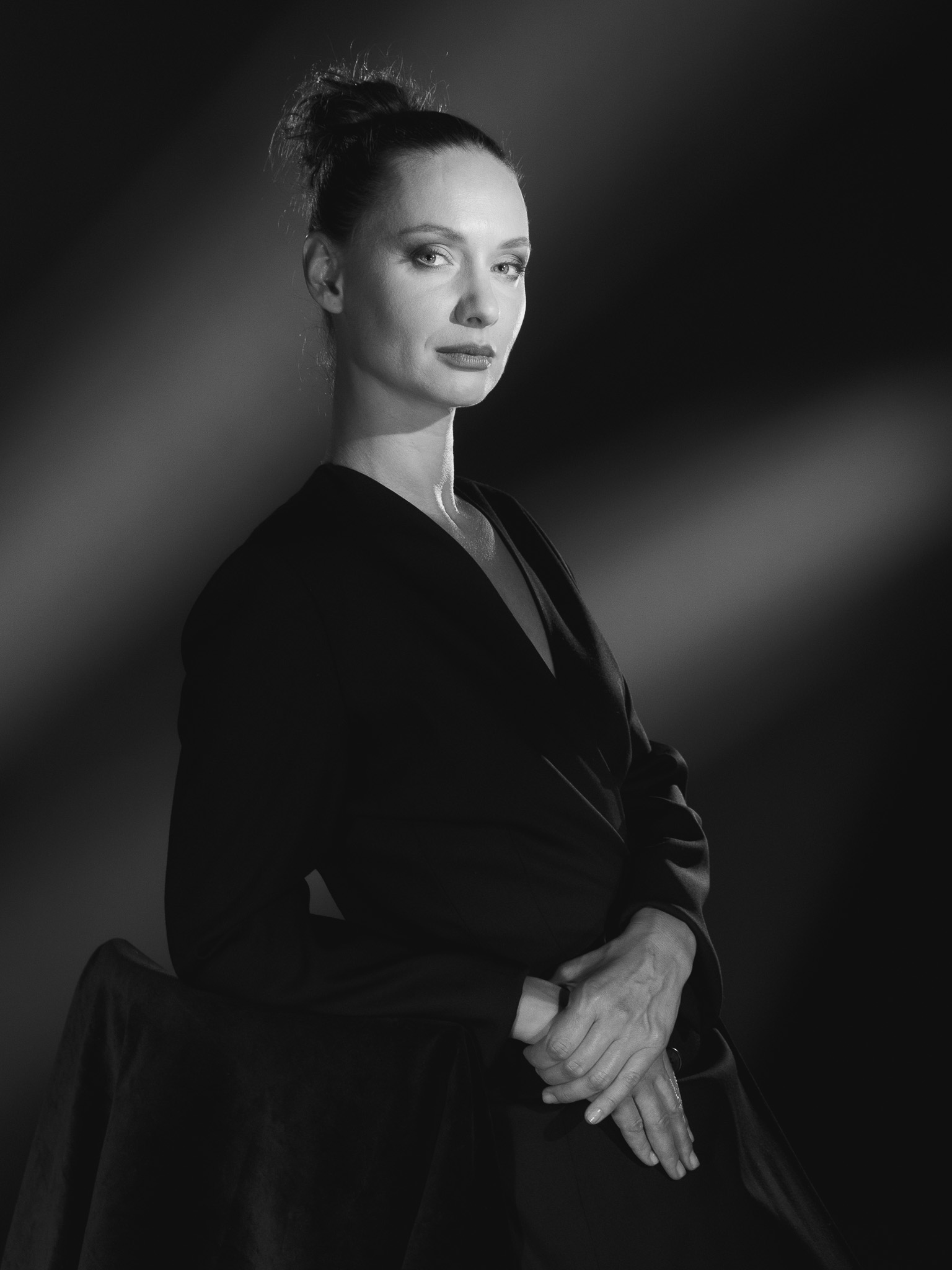 Portrait féminin en noir et blanc éclairé en studio, visage et silhouette modelés par la lumière