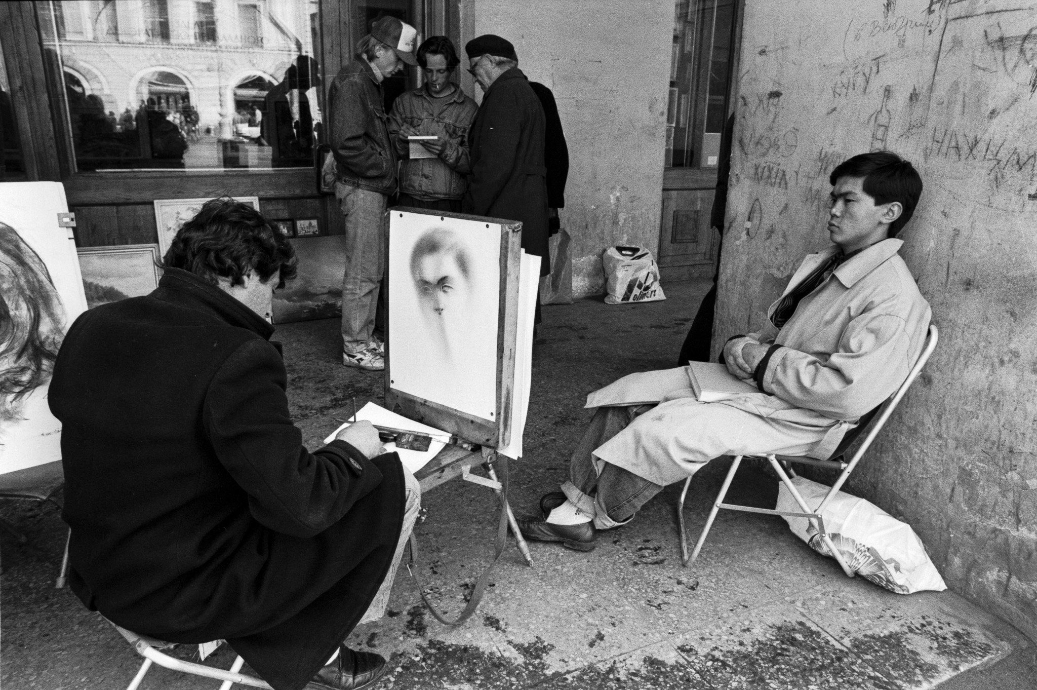 Portraitiste réalisant le dessin d’un homme dans une rue de Saint-Pétersbourg en 1992