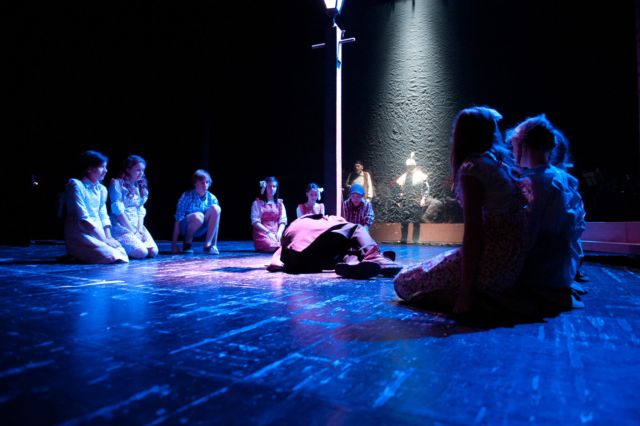 Groupe de comédiens sur une scène de théâtre alsacien éclairée de bleu