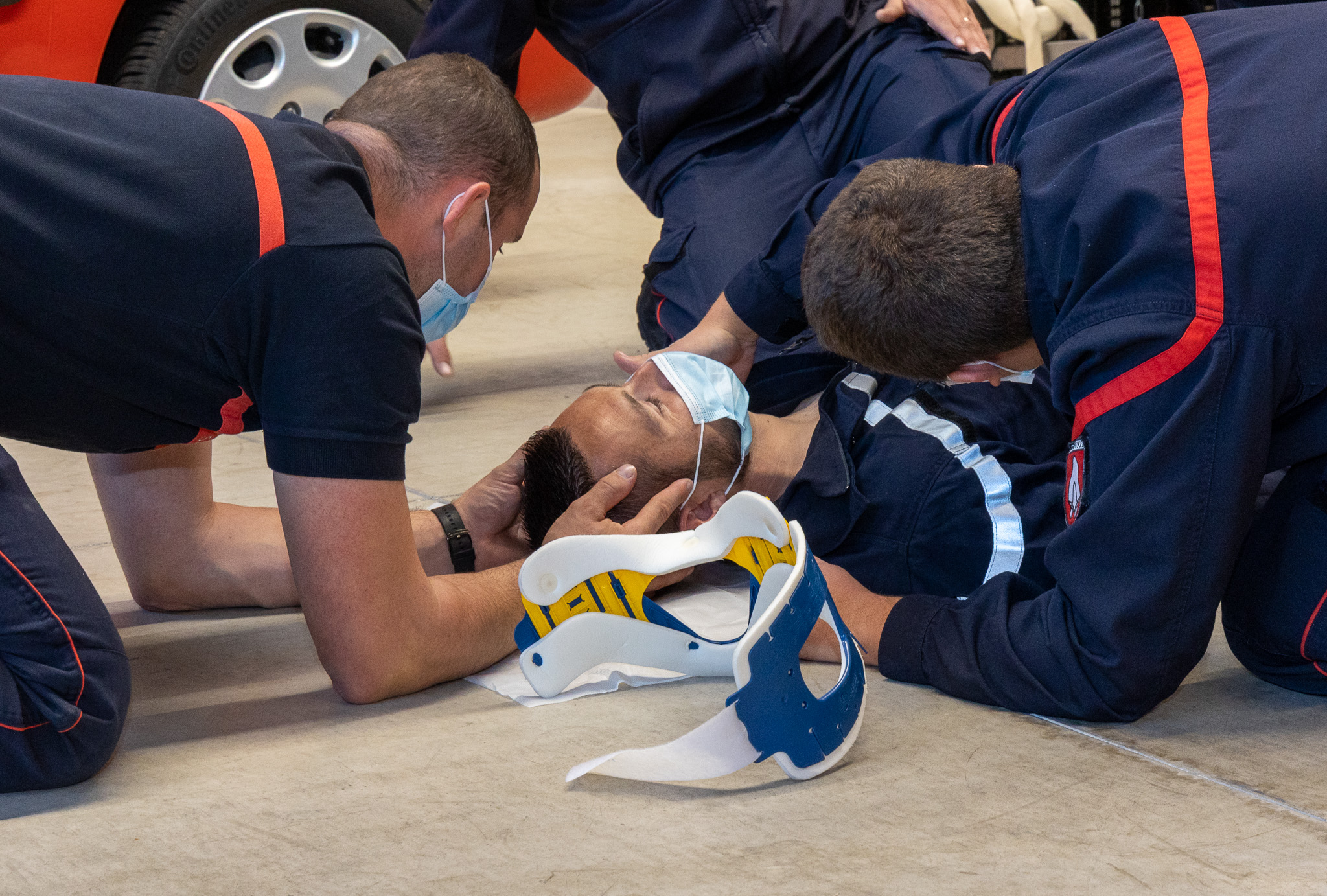 Sapeurs-pompiers réunis autour d’une victime lors d’un exercice de secours et de formation