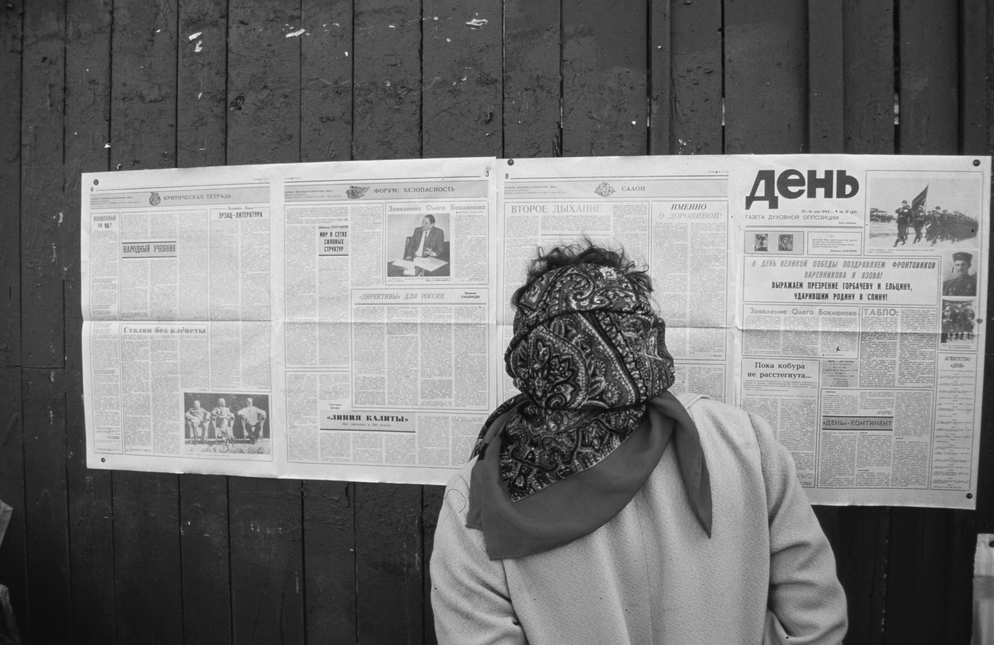 Femme lisant des journaux affichés dans la rue à Saint-Pétersbourg en 1992