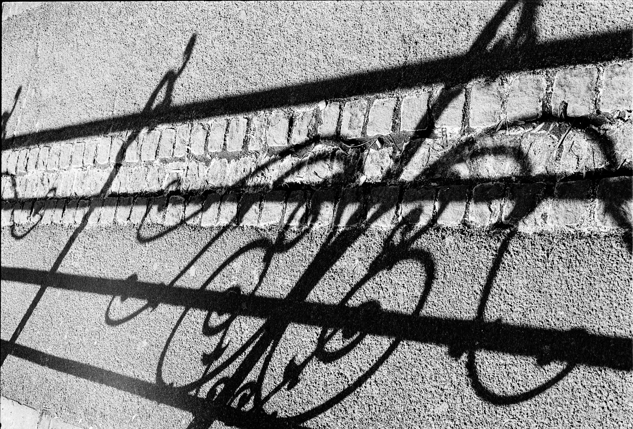 Ombres anguleuses d’un garde-corps projetées sur un sol clair