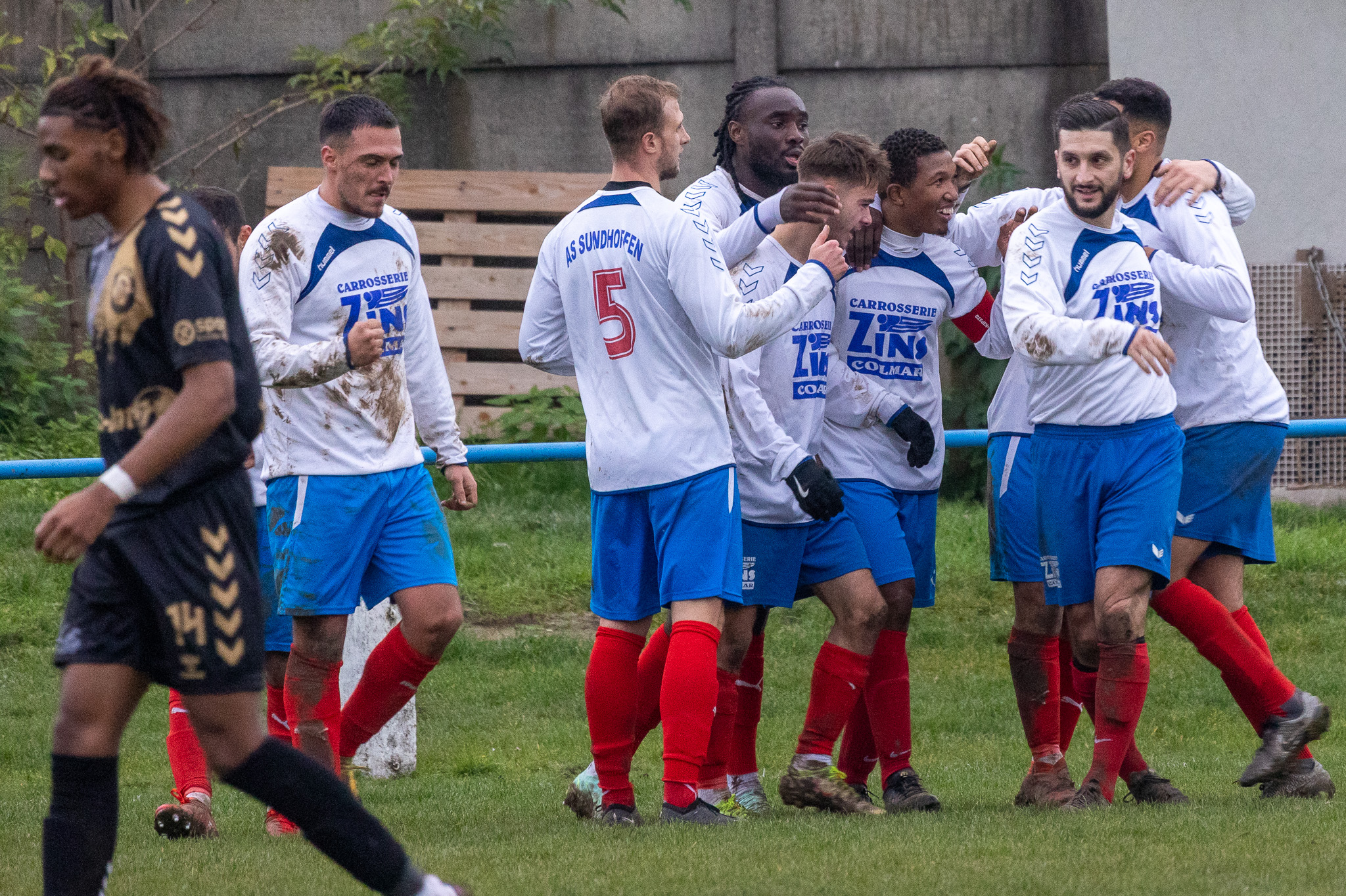 Joueurs de football réunis sur le terrain après une action à Sundhoffen