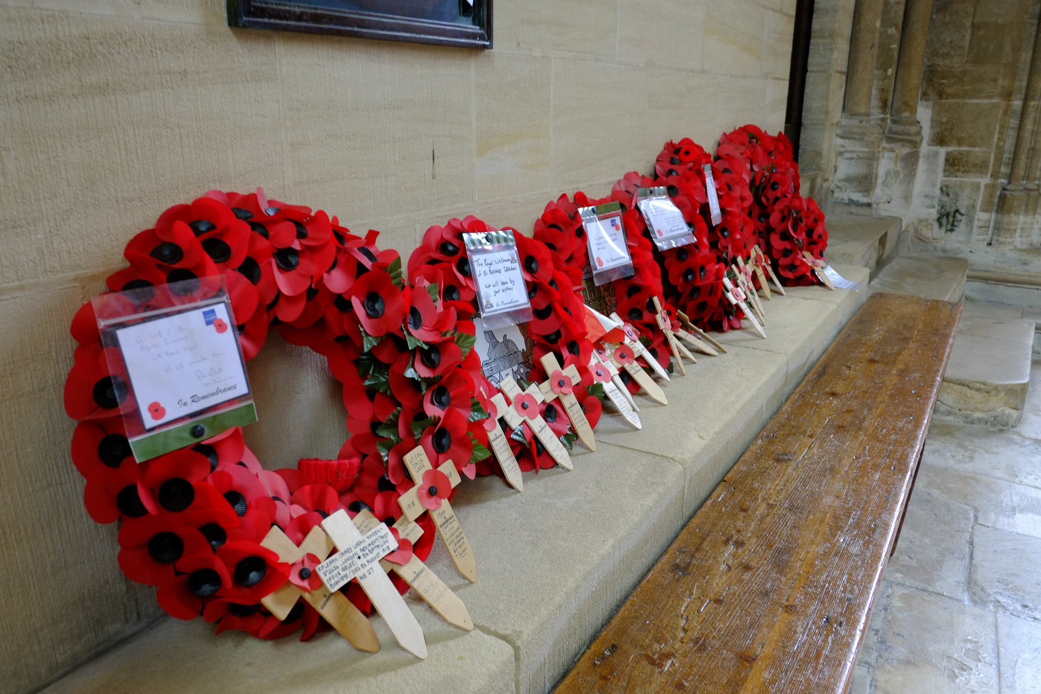 Couronnes de coquelicots rouges et croix commémoratives déposées dans une église