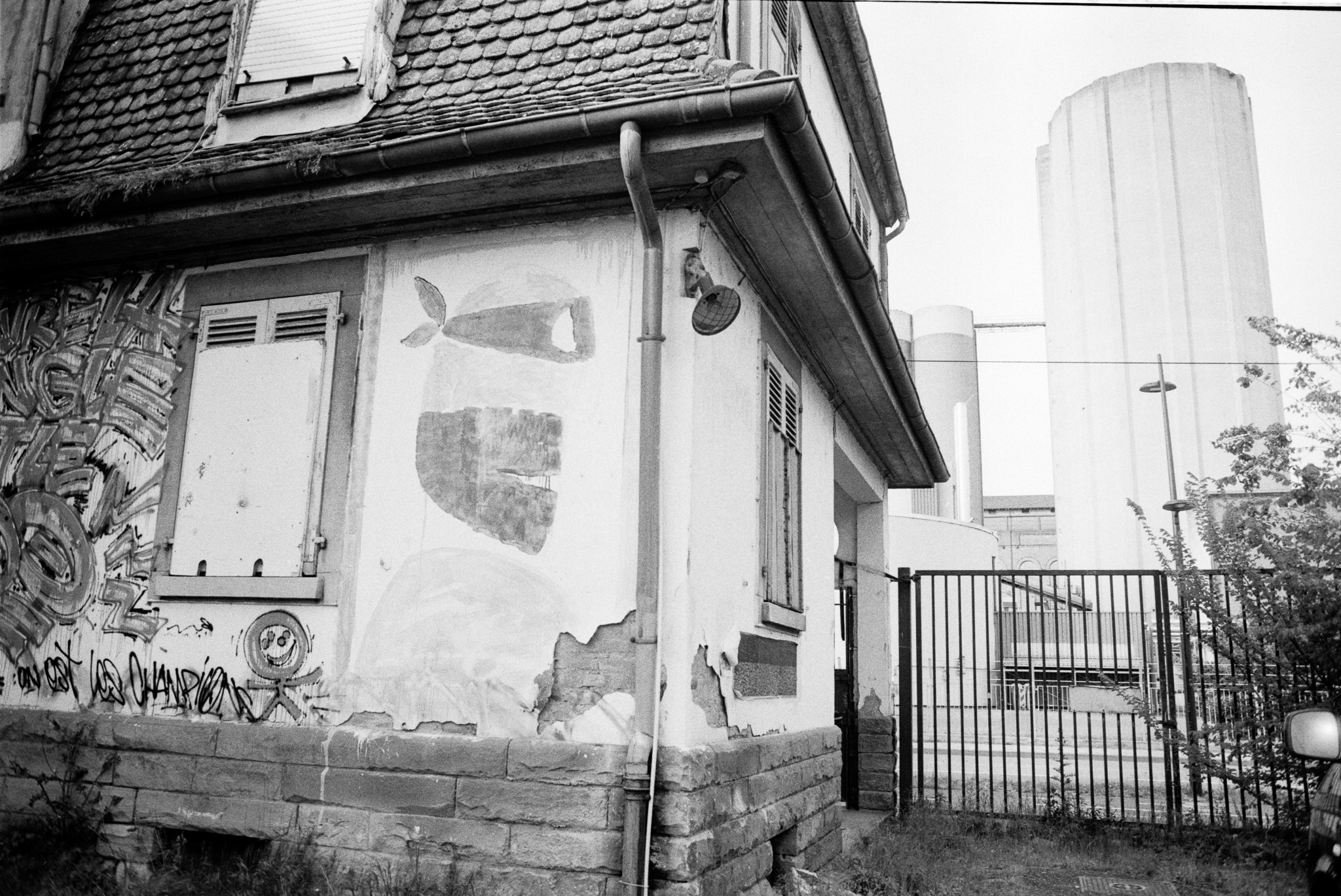 Petite maison ancienne au premier plan devant les hauts silos du Port autonome de Strasbourg