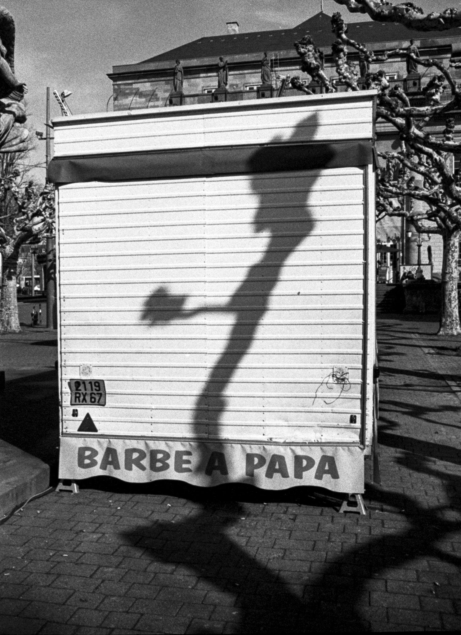 Rideau fermé d’un stand de barbe à papa avec une grande ombre projetée au sol