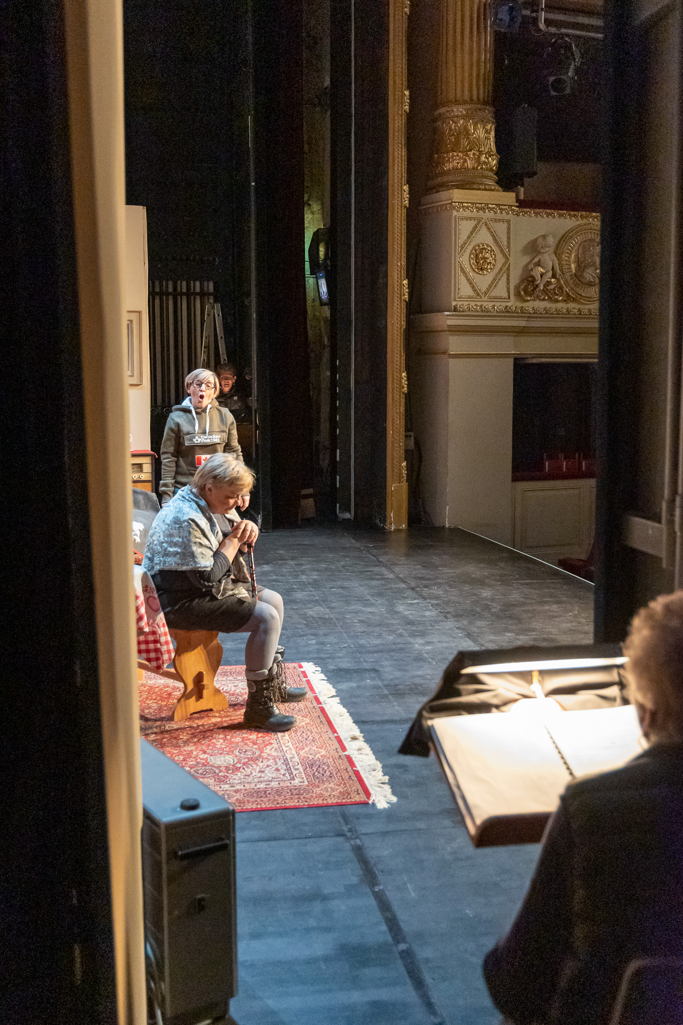 Vue depuis les coulisses vers le plateau d’un théâtre pendant une représentation