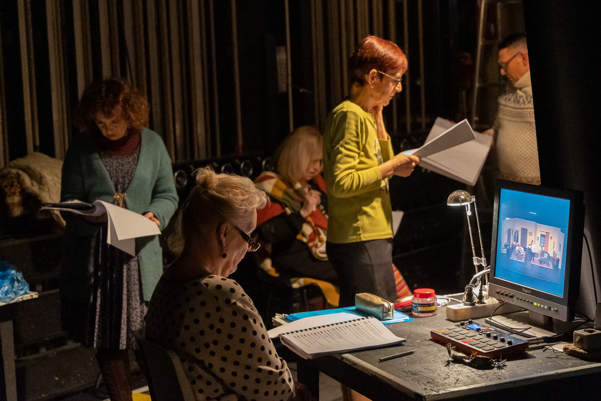 Membres de la troupe réunis en coulisses autour des textes et du suivi de la représentation