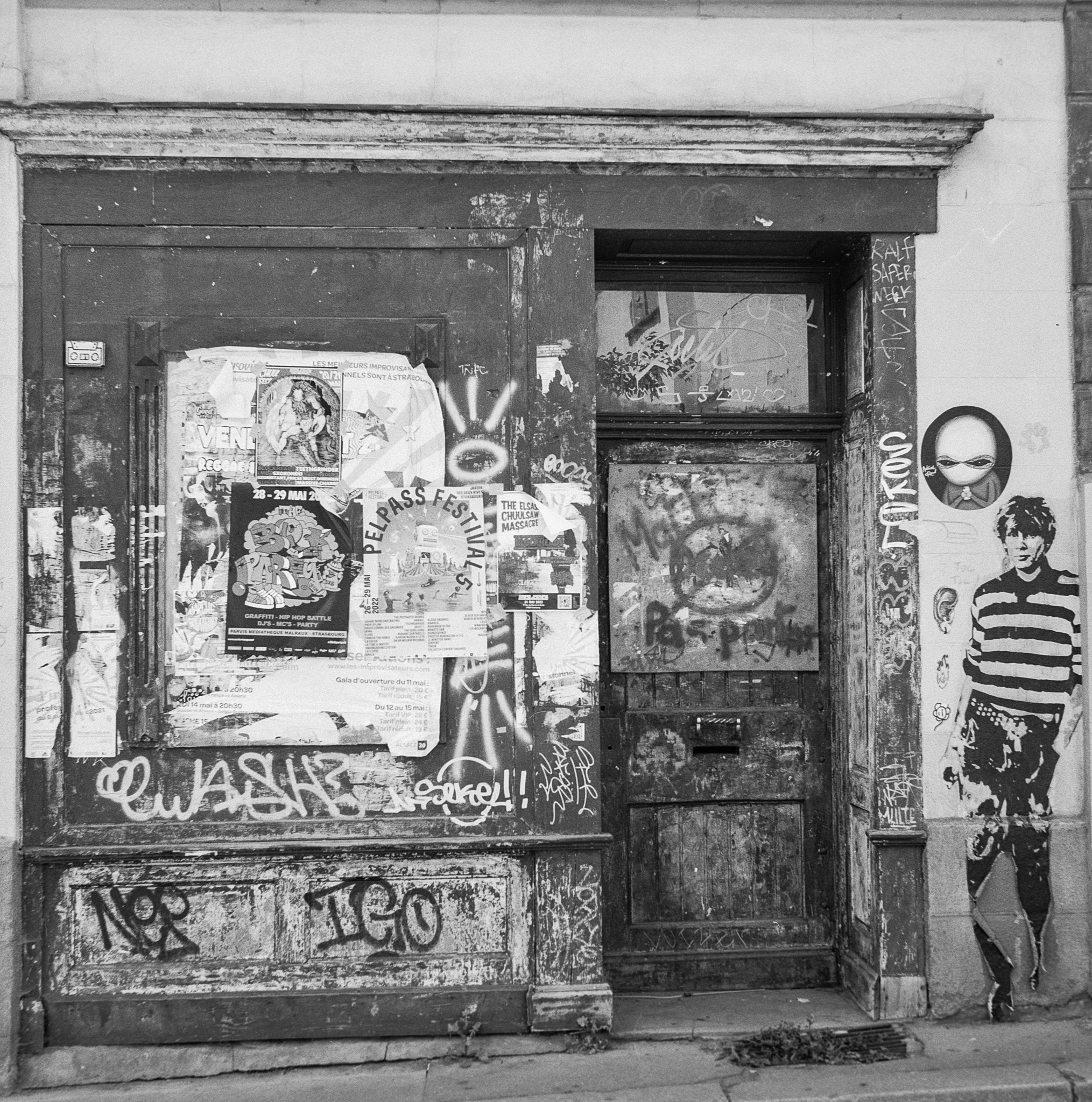 Ancienne devanture couverte d’affiches, de graffitis, d’autocollants et de dessins