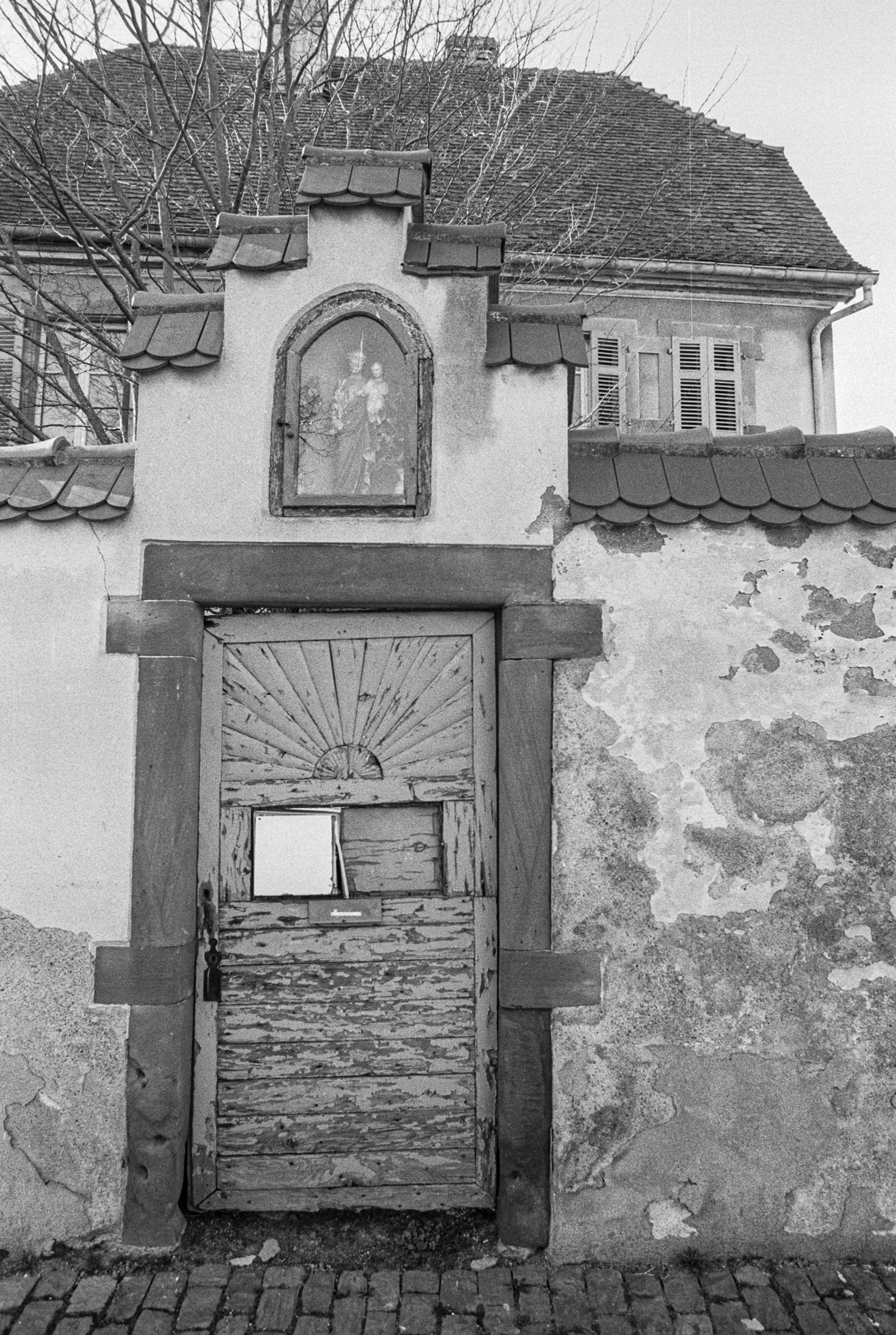 Ancienne porte surmontée d’une niche religieuse sur une maison de Sainte-Croix-en-Plaine aujourd’hui détruite